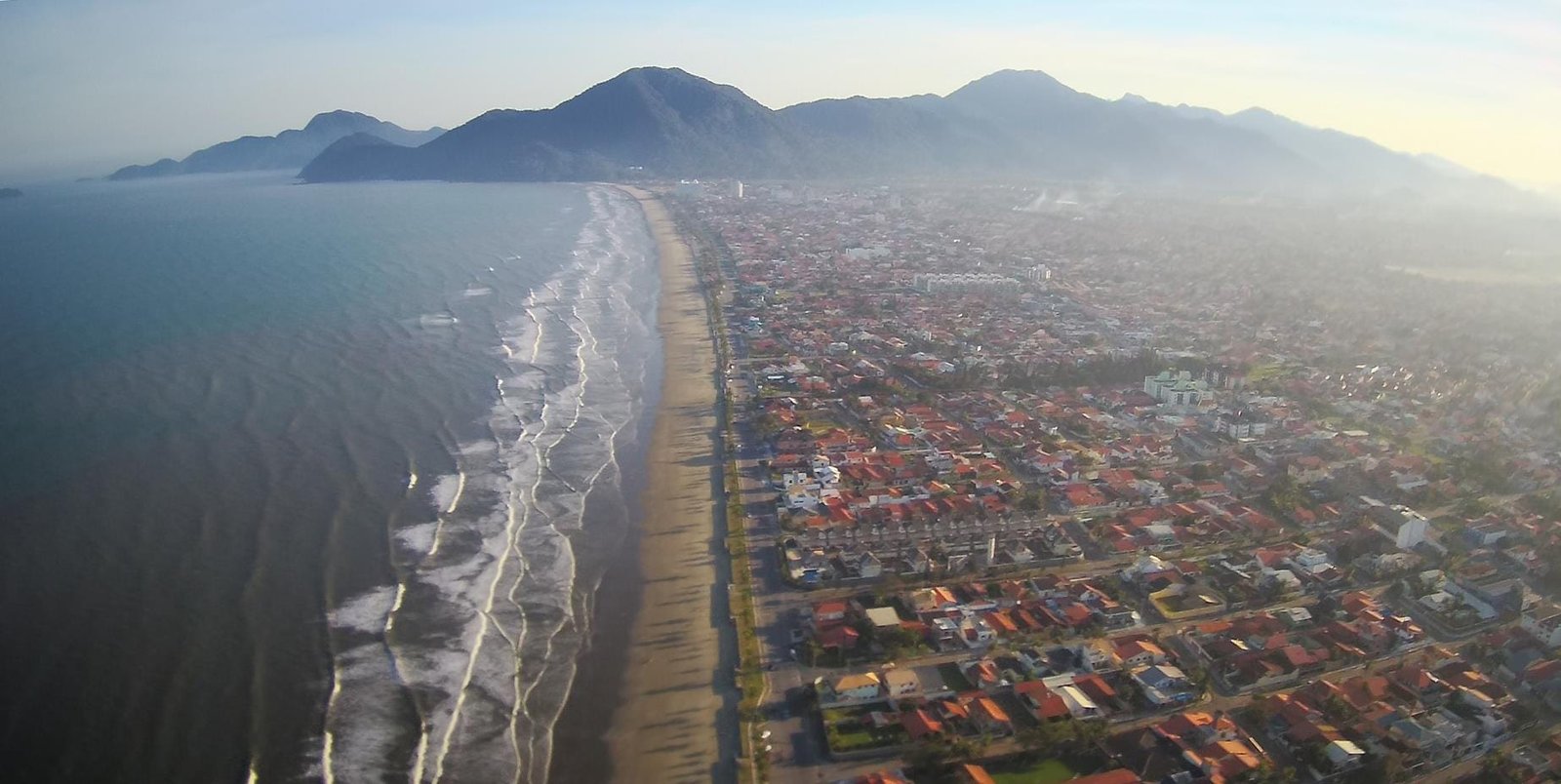 "Vista aérea panorâmica das praias e da cidade de Peruíbe, mostrando a natureza preservada do litoral"