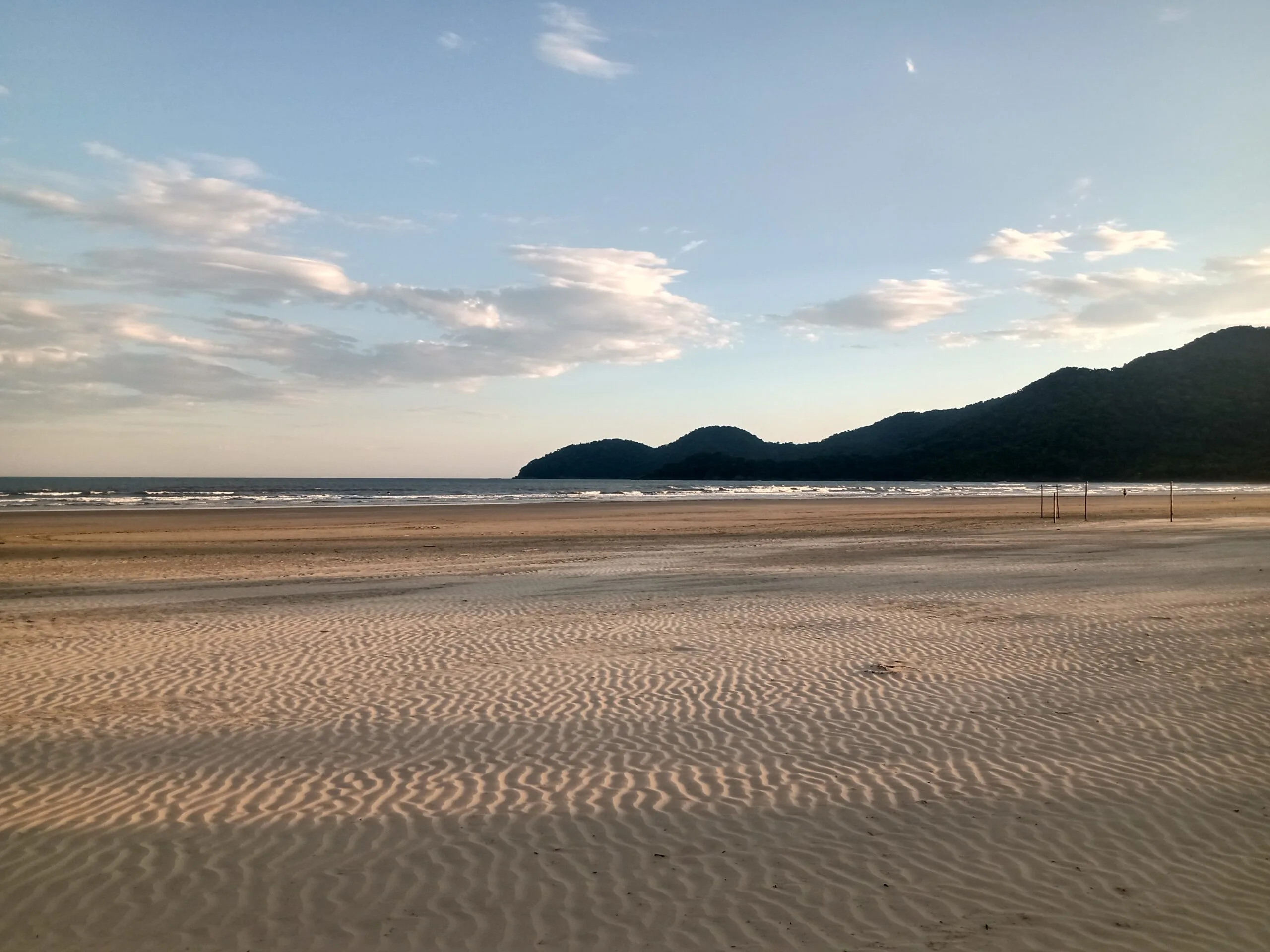 "Praia do Guaraú em Peruíbe cercada pela mata atlântica, destino ecoturístico próximo à Pousada"